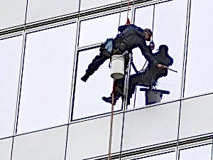 Güvenli ip kullanarak dış cephe için cam temizliği yapan personel